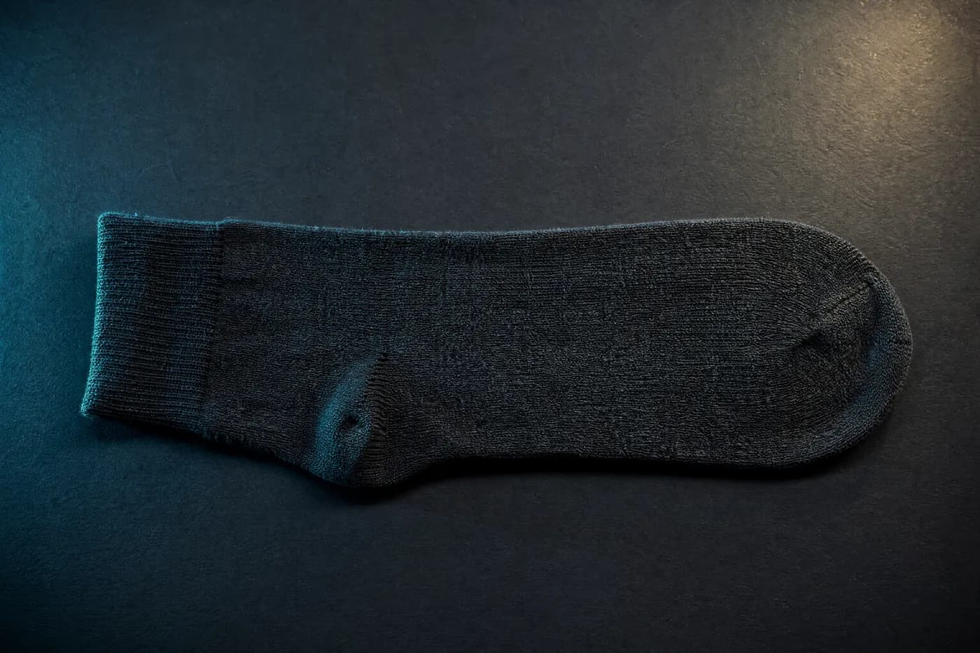 Close macro of the toe and heel zone of a plain knitted sock under raking light